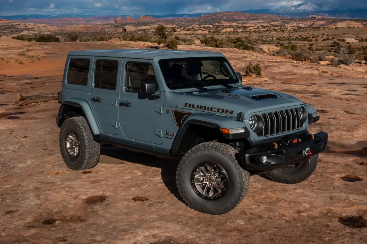 2025 Gray Jeep Wrangler Rubicon SUV parked on red rock terrain with distant mesas and mountains