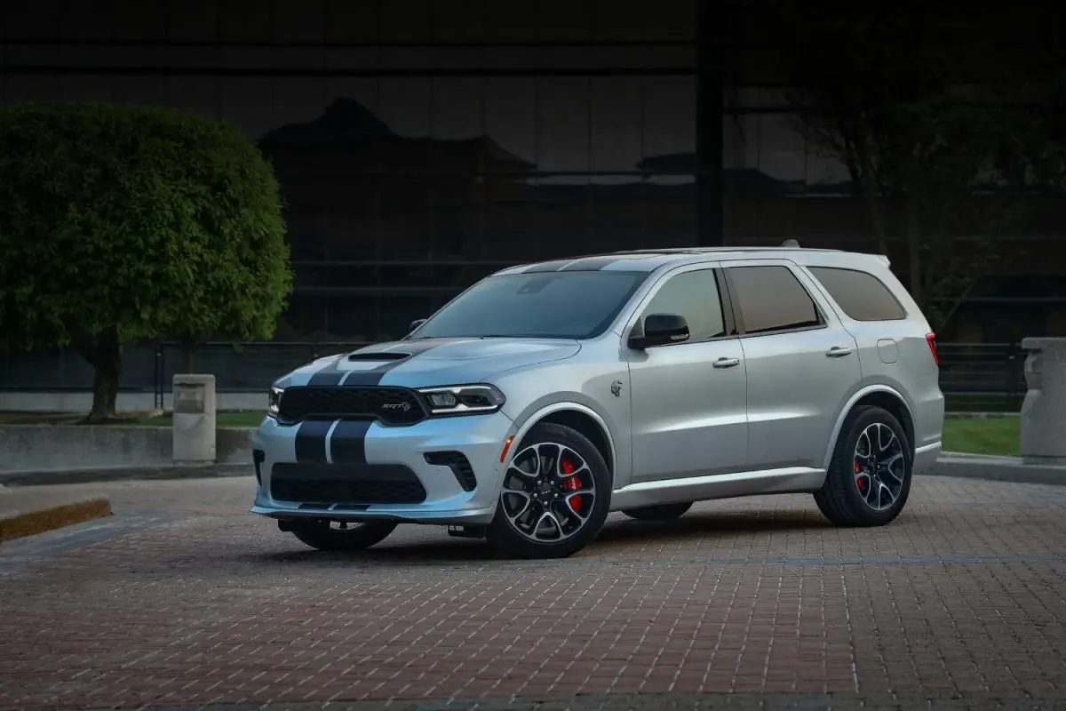 2024 Silver Dodge Durango SRT Hellcat SUV with black racing stripes parked on a brick driveway