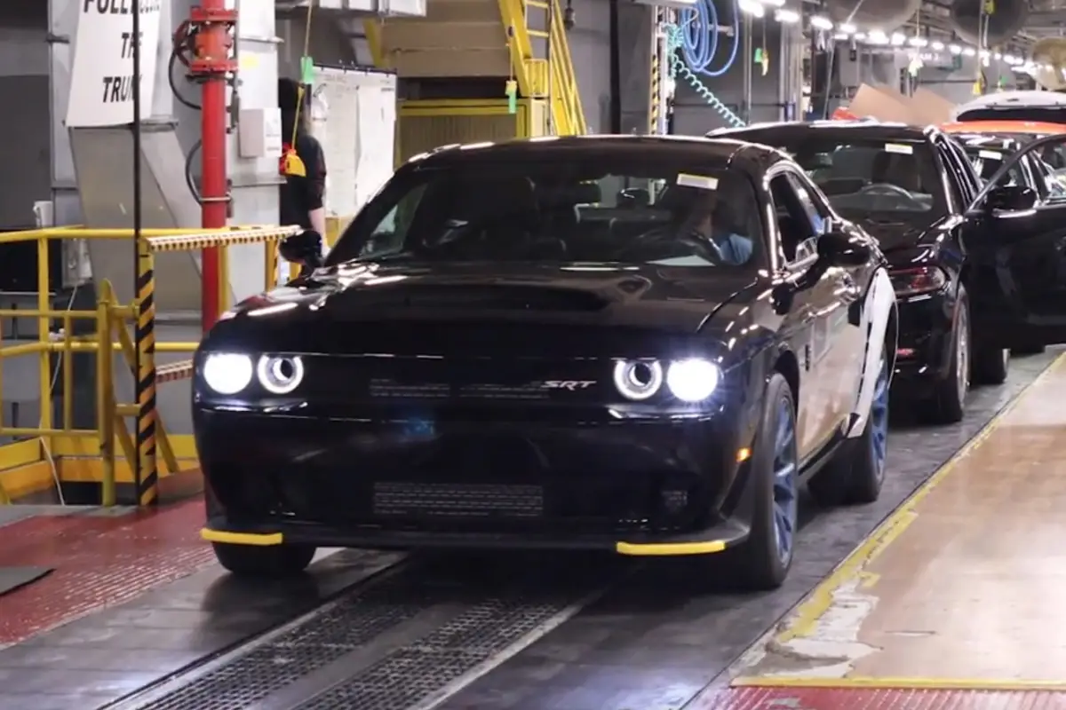 2023 Black Dodge Challenger SRT muscle car rolling down the factory assembly line during production