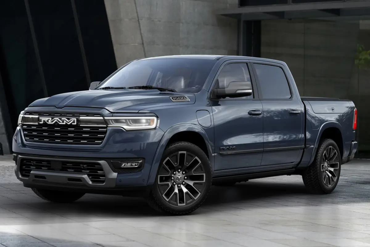 2025 Blue-gray Ram 1500 pickup truck parked outside a modern building, front three-quarter view