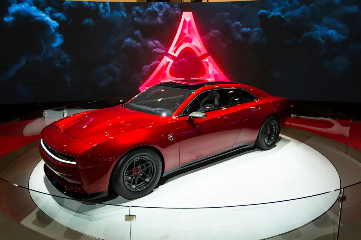 2023 Red Dodge Charger Daytona SRT concept car displayed on a rotating stage at an auto show