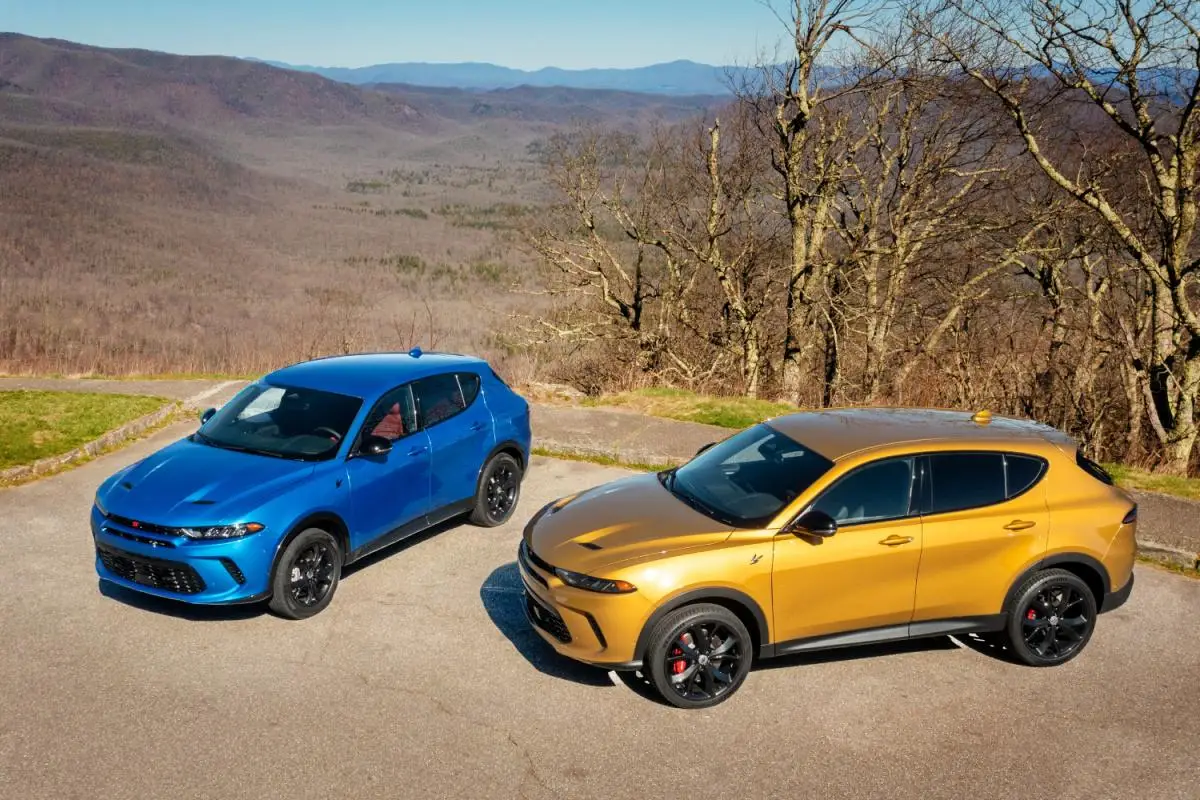 2024 Blue and yellow Dodge Hornet compact SUVs parked together on a mountain overlook