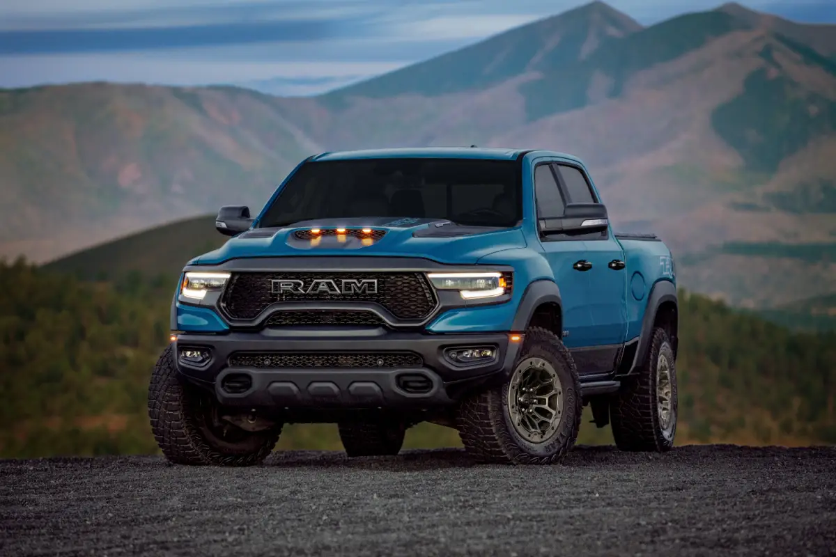 2024 Blue Ram 1500 TRX high-performance off-road pickup truck parked on a hilltop with mountain views
