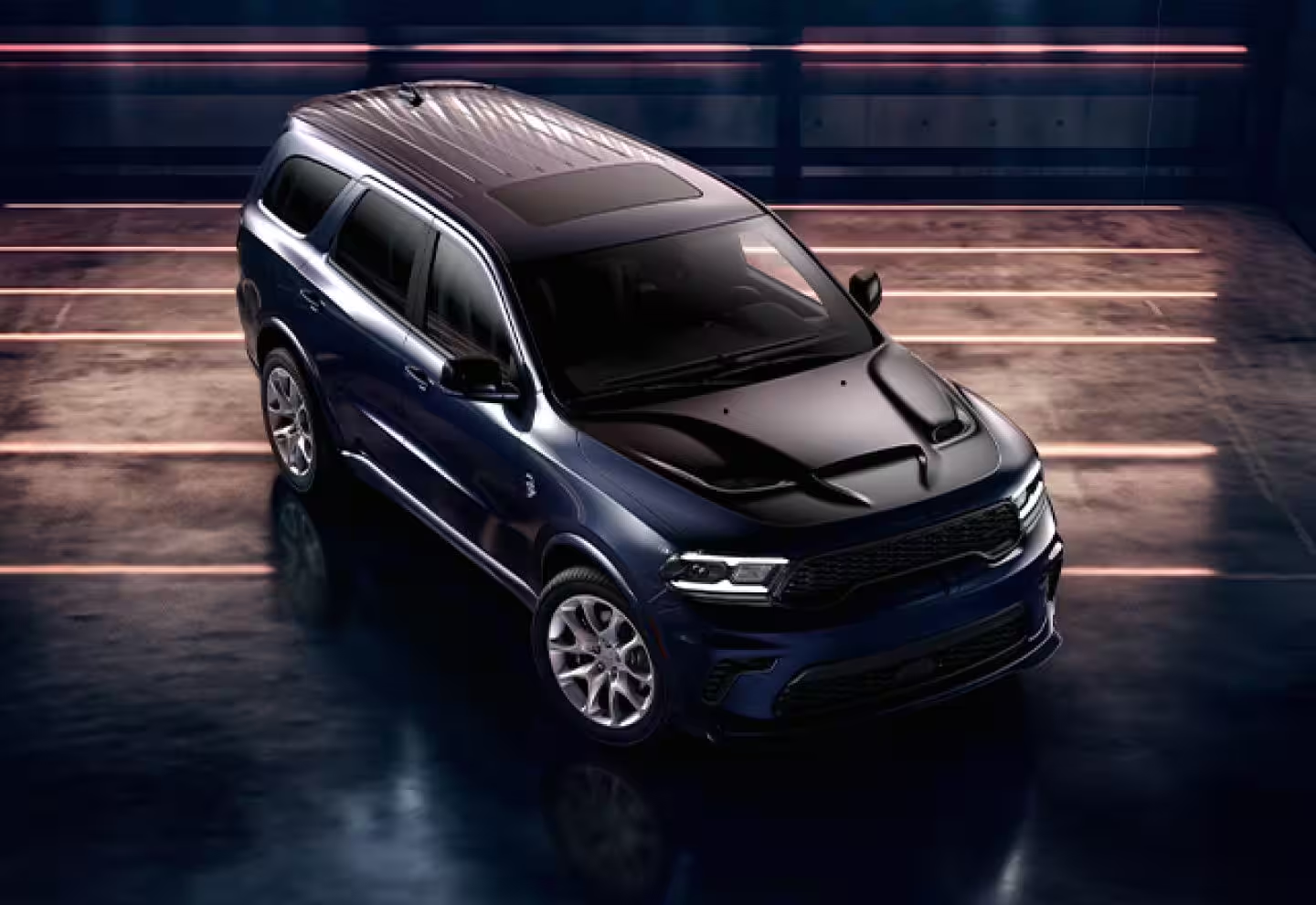 2025 Navy blue Dodge Durango R/T SUV in a dramatic studio setting with ambient lighting, front three-quarter aerial view