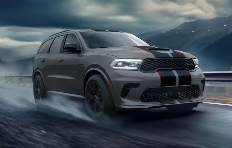 Gray Dodge Durango R/T SUV with red racing stripes driving on a wet mountain road